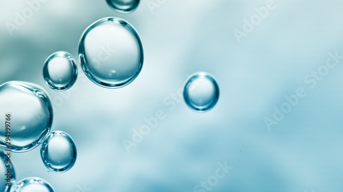 transparent gas bubbles on water surface. Worms-eye low angle with crystal bubbles in purified water on blue background. cosmetic background with copy space