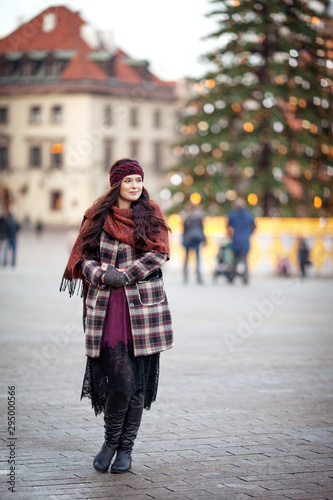 Beautiful joyful woman portrait in a city. Smiling girl wearing warm clothes and hat in winter or autumn