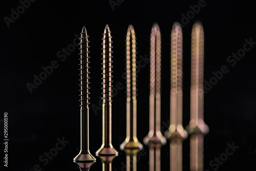 row of spotless metallic screws isolated on black