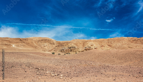 wallpaper poster desert landscape  wasteland dunes foreground and sand stone mountain ridge vivid blue sky background with empty copy space for text 