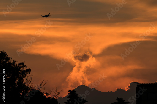 An airplane heading to Guatemala international Airport for landing with the fuego volcano smoking in a sunset