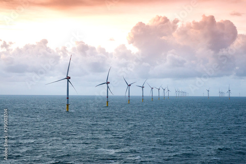 Sunset over offshore wind farm - green power generation