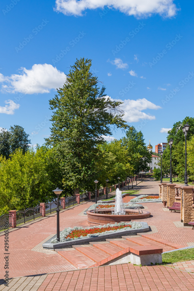 Walking along the alley with a fountain on the banks of the Vitba River in the city of Vitebsk, Belarus. Perspective view.