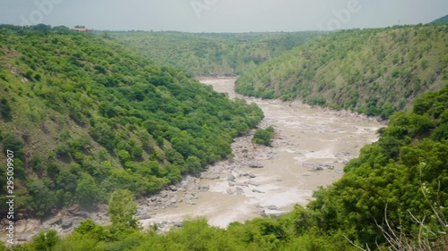 Pan shot of waterfalls flowing into a valley photo