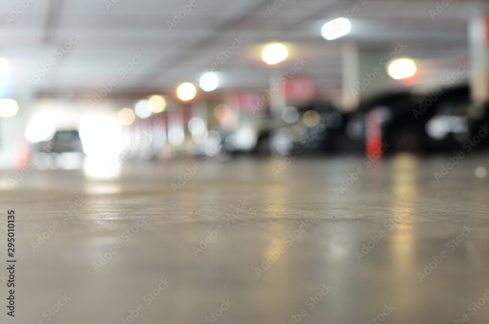 Blurred background of indoor car park with bokeh. Abstract blur car park background. Abstract blur car parking in shopping mall.