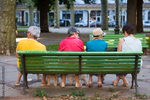 des personnes âgées assises sur un banc parlent photo