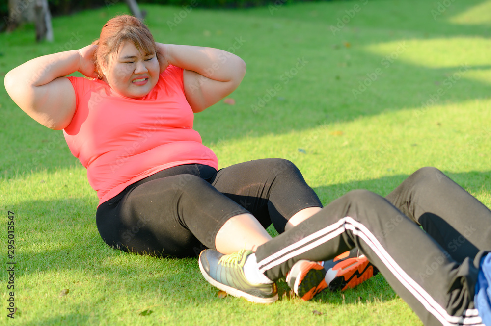 plump fat woman try lift up body exercise with trainer assist and ...