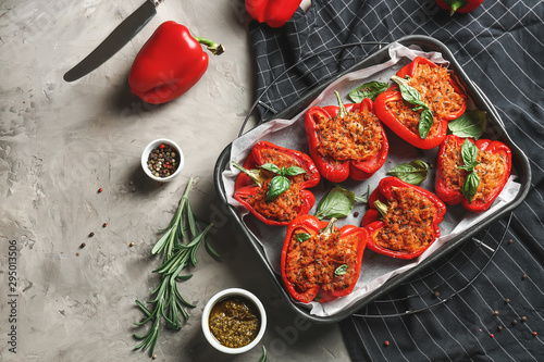 Canvastavla Baking dish with tasty stuffed pepper and sauce on grey background