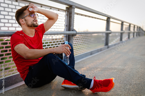 Man runner taking a break during training outdoors. Jogger resting after running.