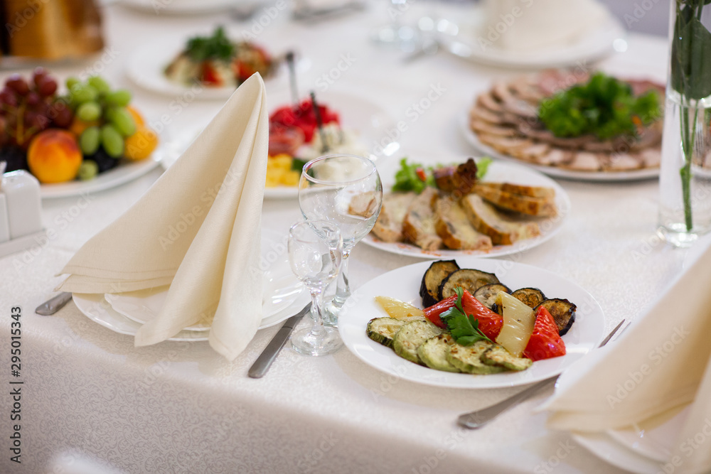 Tables setting at a luxury wedding. Table for guests. Dishes and drinks. Floral decorating, white chairs and table. Wedding table preparation. top view. horizontal photo