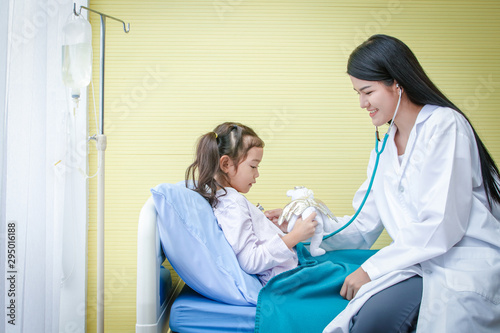 Asian female doctors use stethoscope to check the heartbeat A little girl in a hospital bed. Concept of child care.