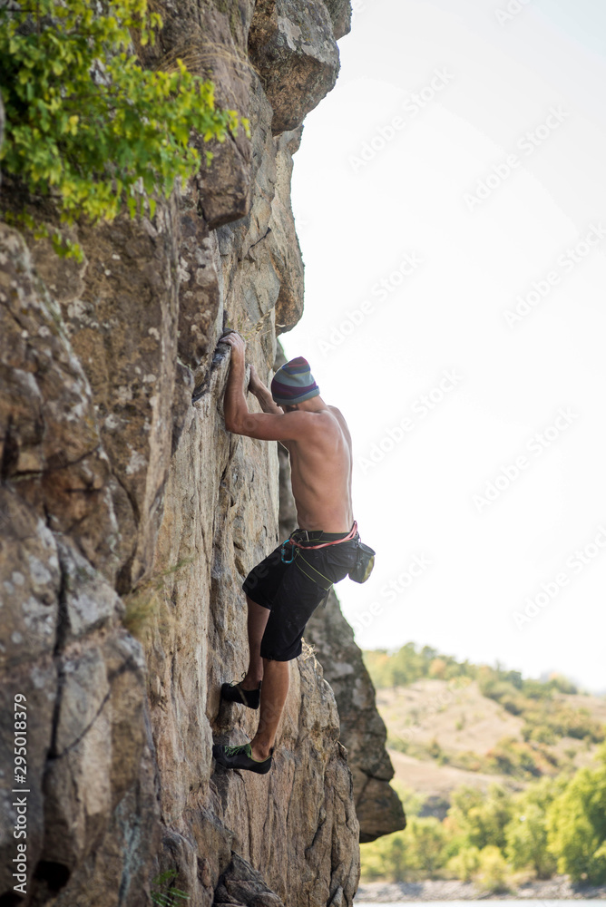 Man cliff climber is climbing a rock. Man cliff climber is climbing a rock.