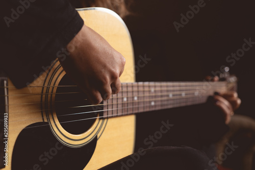 girl plays an acoustic guitar. close-up of strings