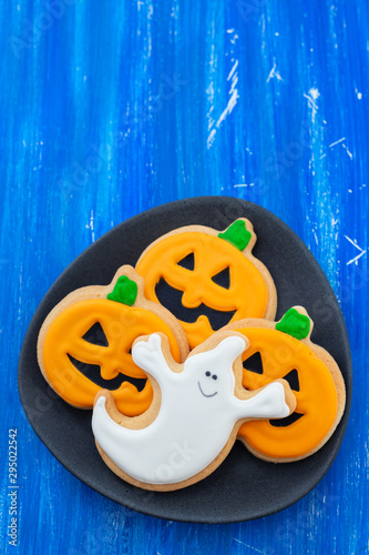 Halloween cookies on black dish on blue wooden background