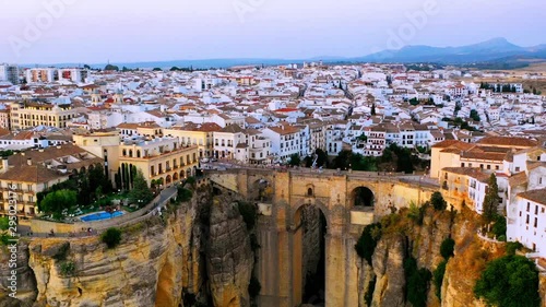 Ronda, Spain. Aerial evening view of New Bridge over Guadalevin River in Ronda, Andalusia, Spain with clear sunset sky in summer. Time-lapse with car and people traffic