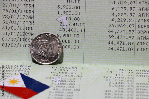 One coin of Philippine peso money on obverse and mini Philippine flag on the book bank. Concept of Saving money.