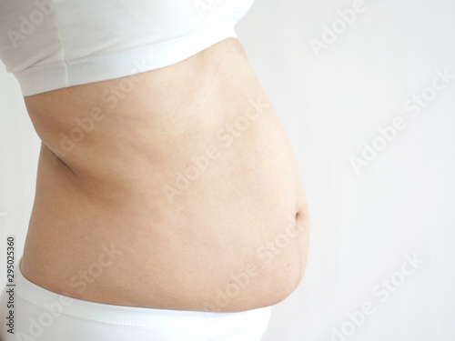 cellulite and belly fat in woman on her abdomen and waist cause of fatty from weight and loss of collagen use for body firming gel or cream product or liposuction concept