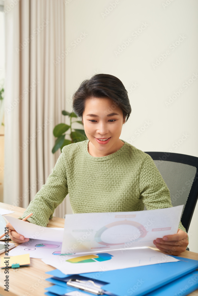 Concentrated woman sit at table reading documents and taking note