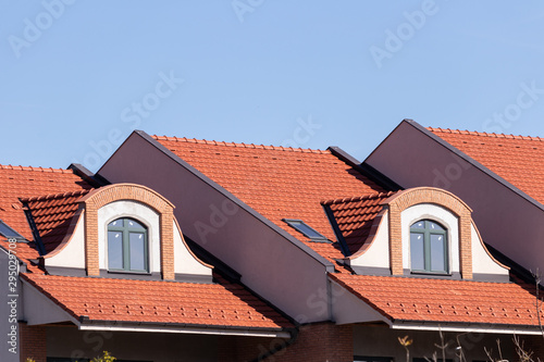 Windows of the attic floor on a bright tiled roof, architectural elements and modern building materials