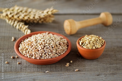 Wheat grain in dishes on the table.grains and wheat ears on a wooden table, top view