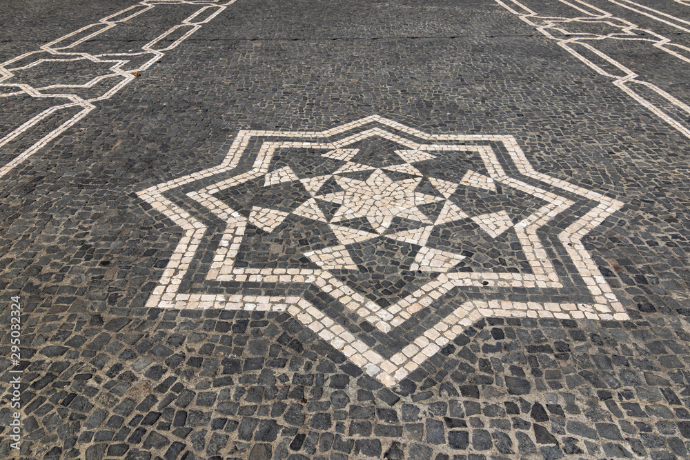 Fototapeta premium Cobbled textured background with eight pointed star mosaic ornament