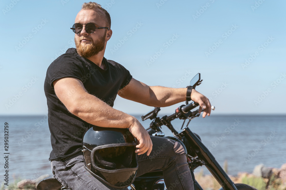 Confident fit biker posing while sitting on his bike