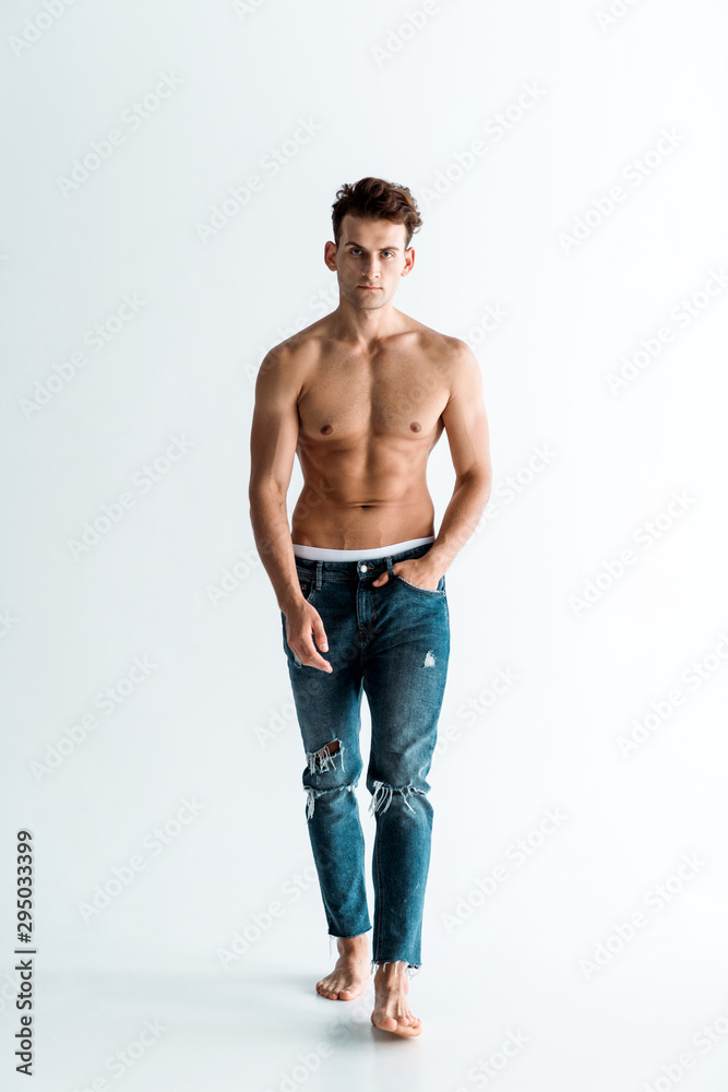 handsome man in jeans walking with hand in pocket on white handsome man in jeans walking with hand in pocket on white