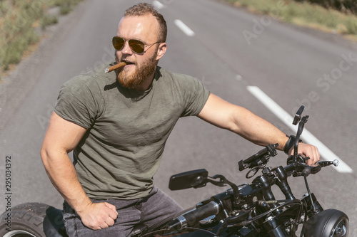 Handsome bearded man with sigar sitting on his bike
