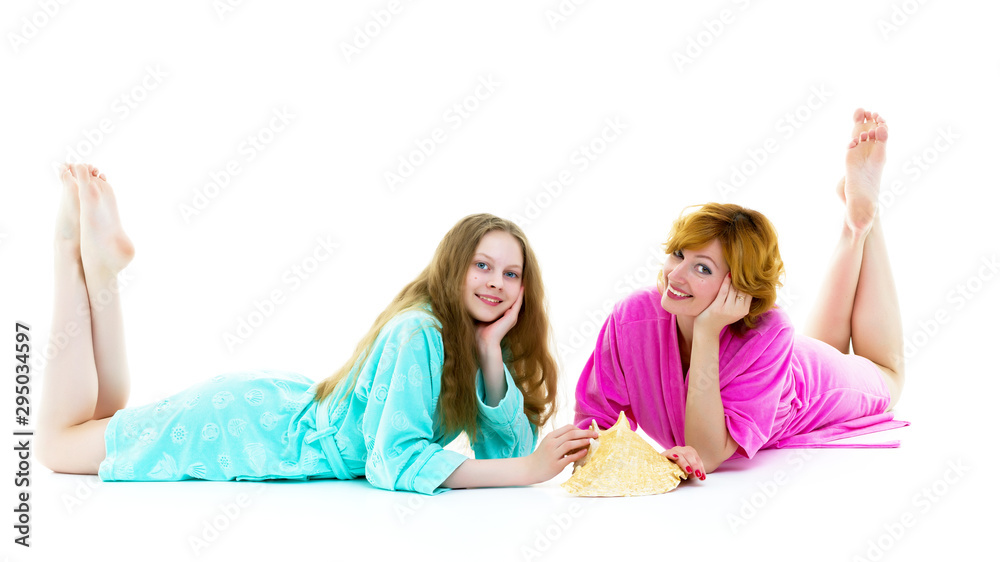Daughter and mother in bathrobes posing in the studio. The conce