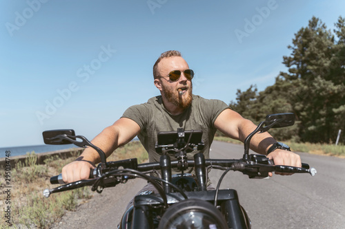 Handsome bearded man with sigar riding his motorcycle