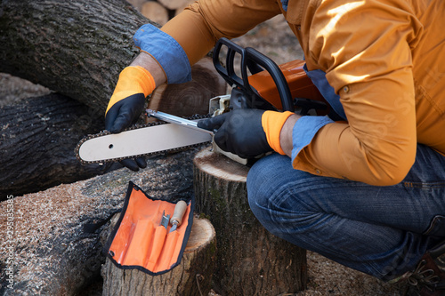 Sharpening a chainsaw Close up on a man sharpening a chainsaw chain with file.