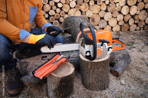 Sharpening a chainsaw Close up on a man sharpening a chainsaw chain with file. photo