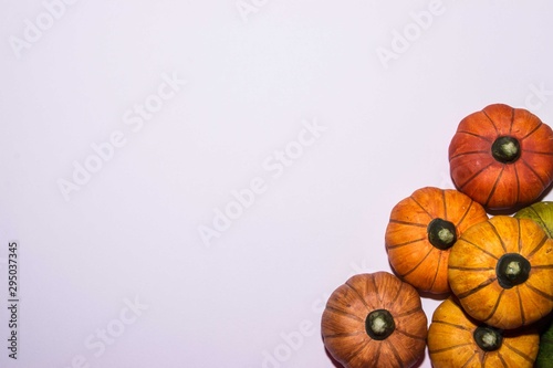 Pile of different color pumpkins on a white background