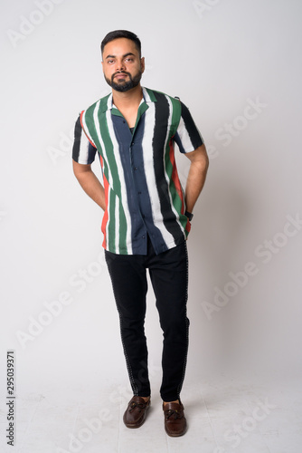 Full body shot of young bearded Indian man