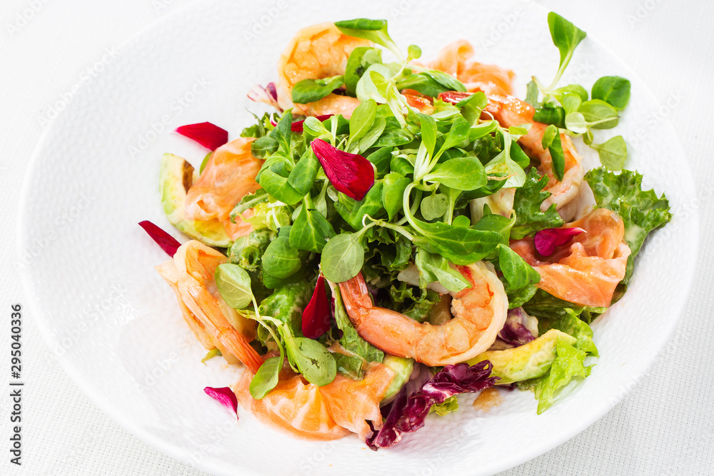 Healthy Salad. Recipe for fresh seafood. Grilled shrimps, prawns, fresh salad lettuce and avocado slices. Healthy Eating. White background. Horizontal photo. Healthy Salad. Recipe for fresh seafood. Grilled shrimps, prawns, fresh salad lettuce and avocado slices. Healthy Eating. White background. Horizontal photo.