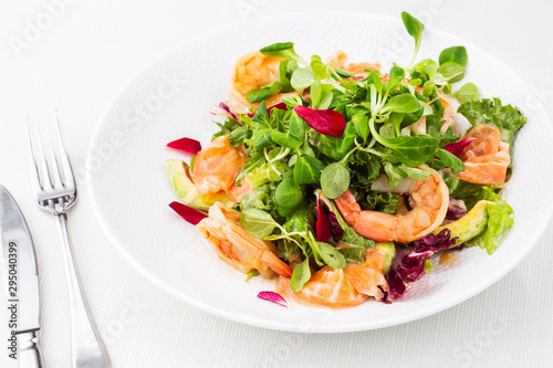 Healthy Salad. Recipe for fresh seafood. Grilled shrimps, prawns, fresh salad lettuce and avocado slices. Healthy Eating. White background. Horizontal photo.