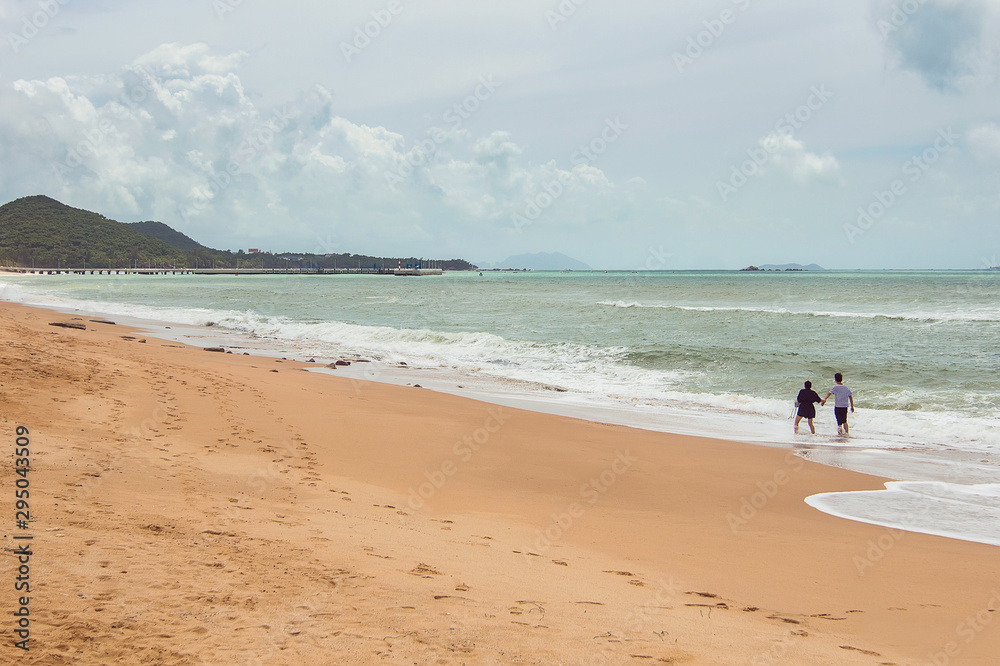 Beautiful romantic couple on Beach in Sanya, Chinese island of Hainan, South China sea Beautiful romantic couple on Beach in Sanya, Chinese island of Hainan, South China sea