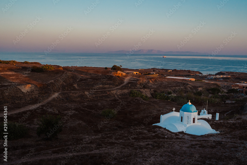 Aerial drone shot of a different side of Santorini. Arid and dry with an iconic church, this is the side tourists don't see. 