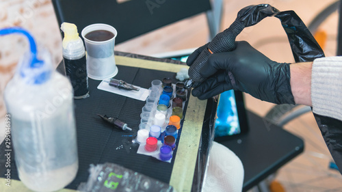 Close-up of tattoo artist work place parts and paint, machines and other equipment. Professional tattooist working tattooing in studio.