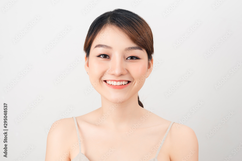 Beautiful smiling woman with clean skin, natural make-up, and white teeth on white background Beautiful smiling woman with clean skin, natural make-up, and white teeth on white background