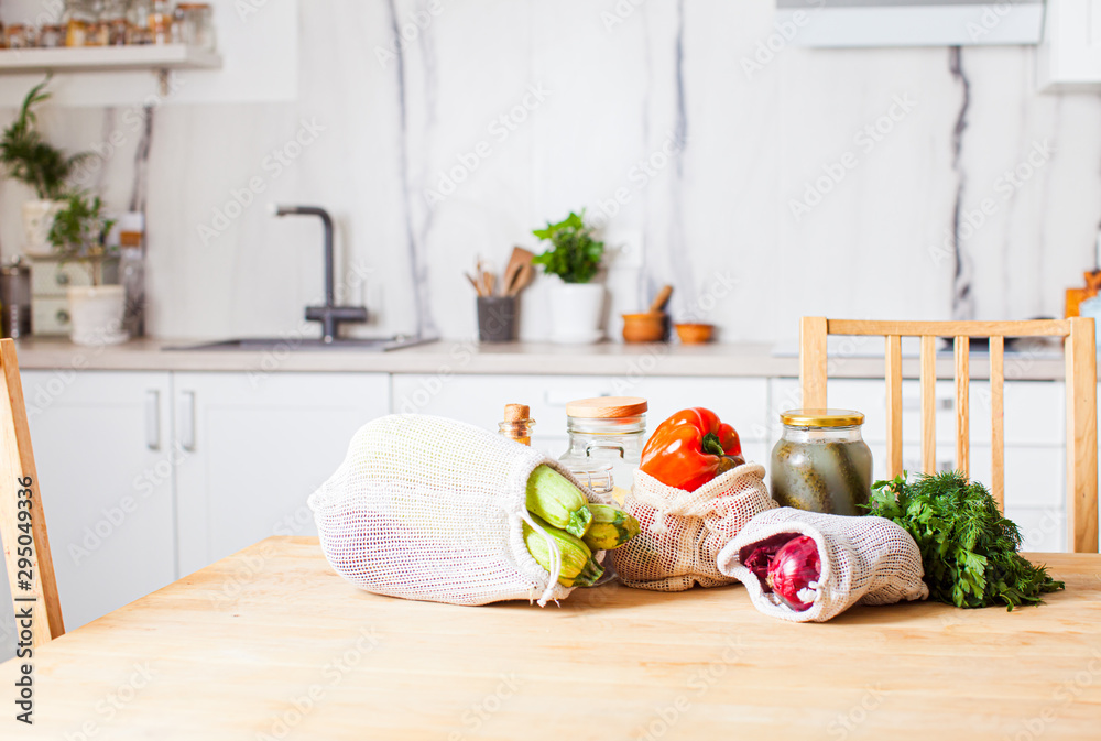Kitchen interiour and table with groceries in textile bags - obrazy, fototapety, plakaty 