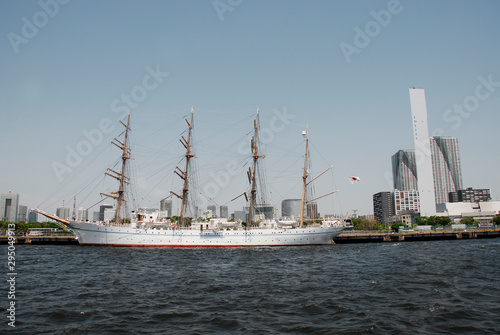 Part of the waterfront area in Tokyo, Japan. An old tall-masted ship contrasts with the modern office buildings surrounding it