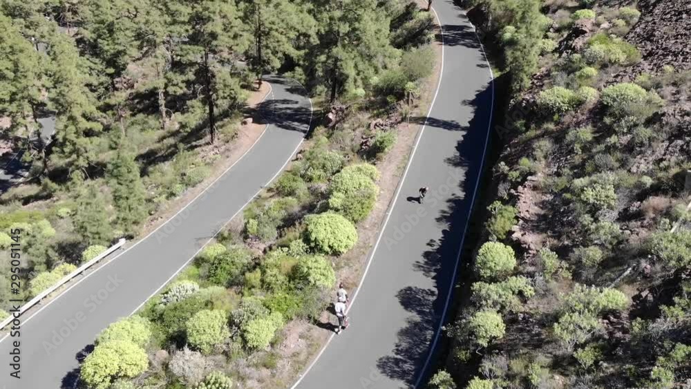 Gran canaria road down a spainish mountain with a skateboarder riding down on a longboard