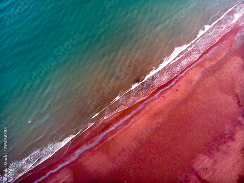 devon beach in paignton with blue water and red beach photo