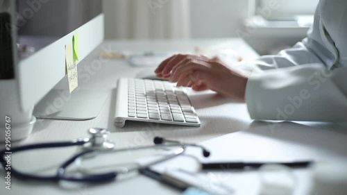 Hands of a doctor working on a computer keyboard. Close-up.