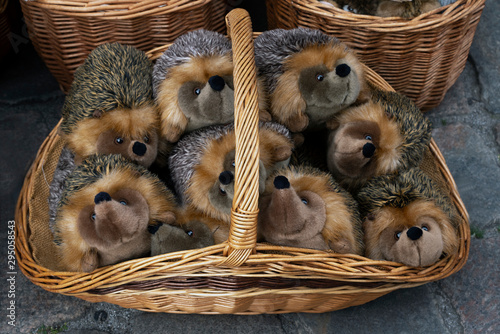 plush hedgehogs in a wicker basket outside. sale of soft toys