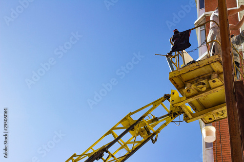 workers working with a car hydraulic lift, when working at high risk at altitude without an insurance rope, the front and rear background is blurred with a bokeh effect
