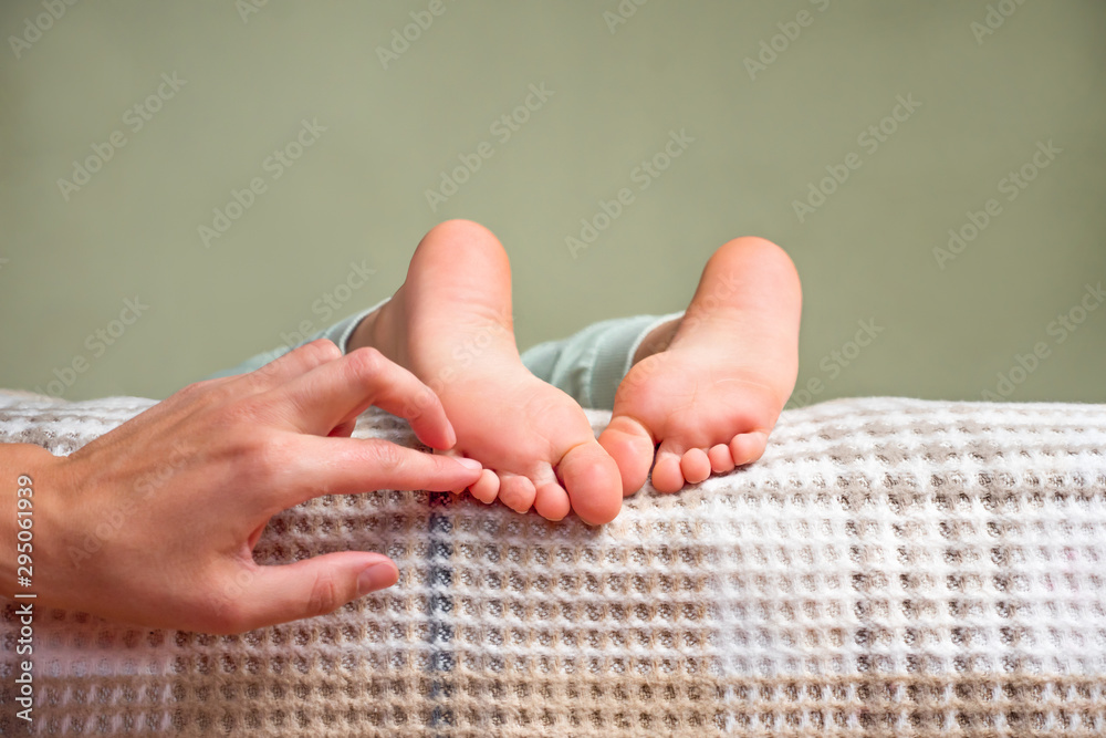 Children's feet. Barefeet on the bed. Kid's feet in bed. Tickling for