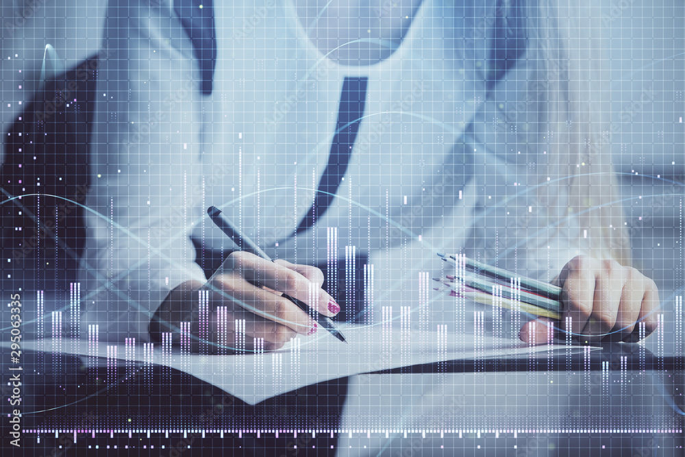 Double exposure of hands making notes with forex chart huds. Stock market concept. Double exposure of hands making notes with forex chart huds. Stock market concept.