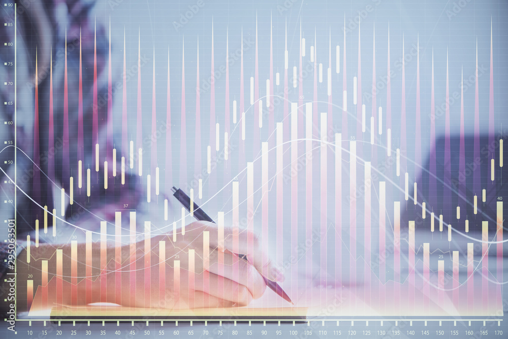 A woman hands writing information about stock market in notepad. Forex chart holograms in front. Concept of research. Double exposure A woman hands writing information about stock market in notepad. Forex chart holograms in front. Concept of research. Double exposure